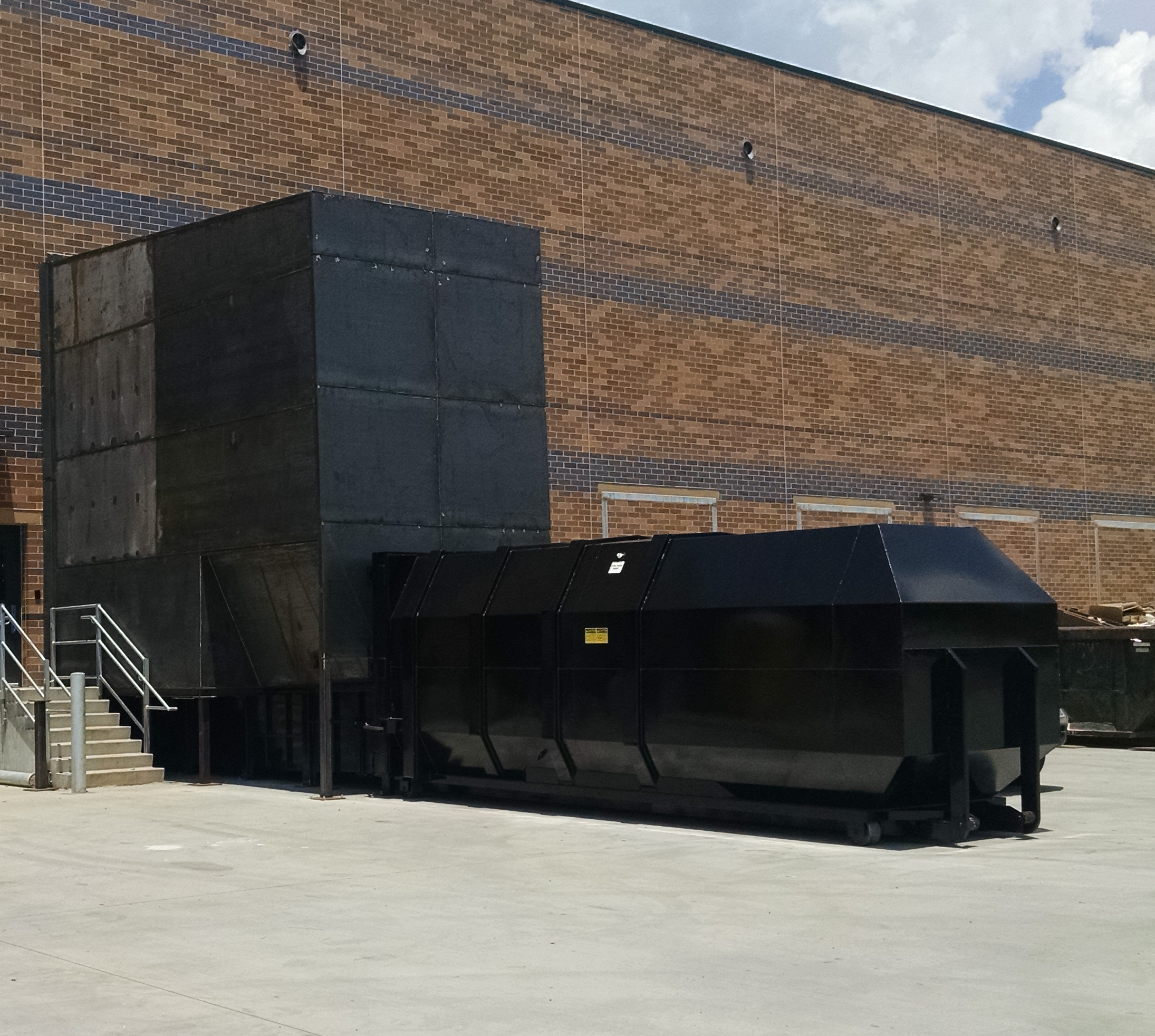 The Stationary (Breakaway) Compactor in this picture is a 4 Yard (4 Yard) stationary compactor manufactured by Bakers Waste Equipment and installed by Bakers Waste Equipment Compactor Solutions. It includes a 40 Yard Container.